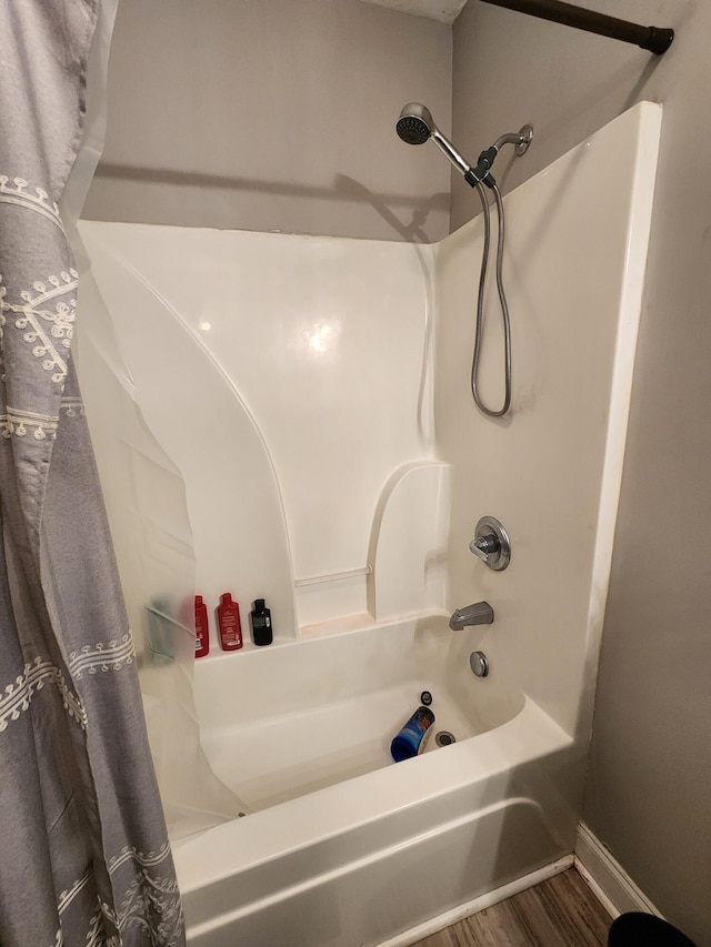 bathroom with hardwood / wood-style floors and shower / bath combo