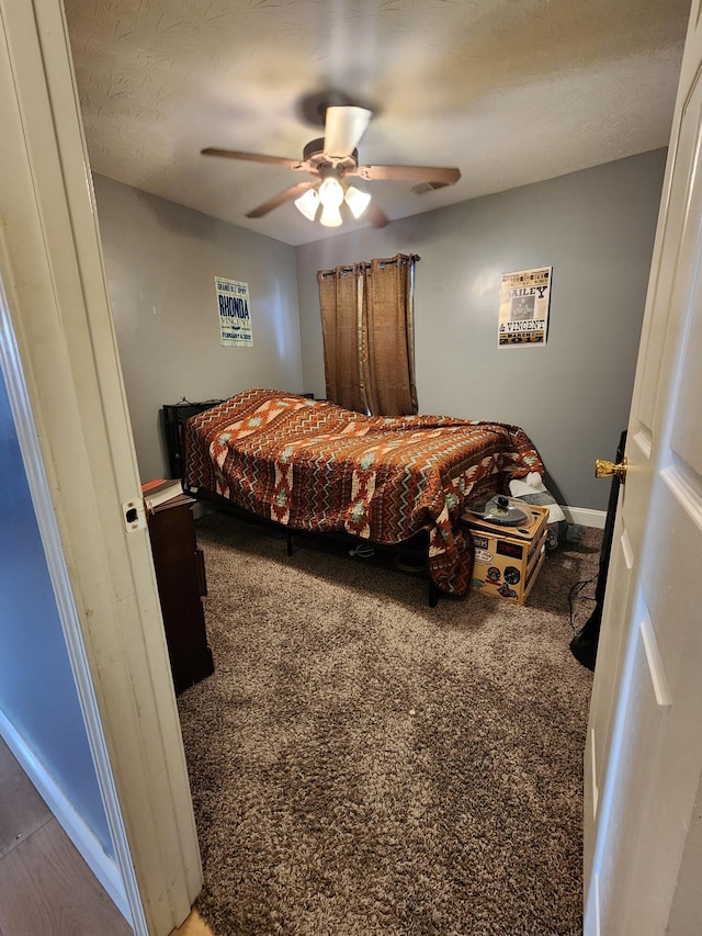 bedroom featuring ceiling fan, carpet floors, and a textured ceiling