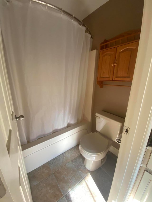 bathroom with shower / tub combo with curtain and toilet