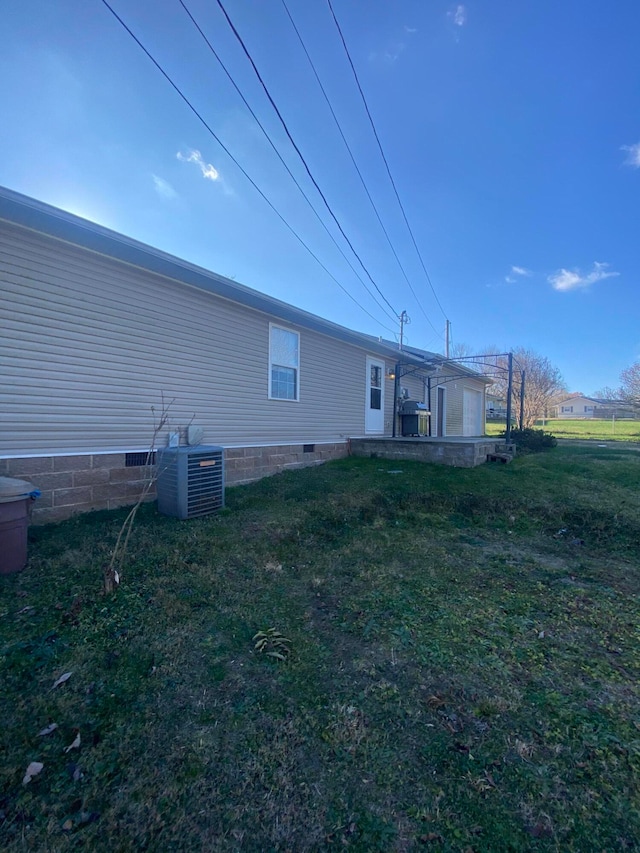 back of property with central air condition unit and a yard