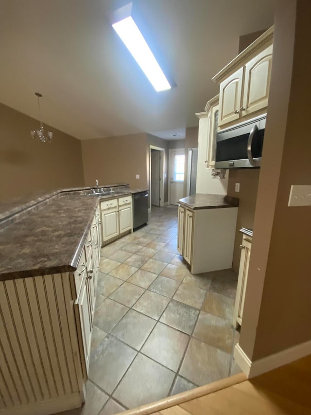 kitchen with cream cabinetry, dishwasher, sink, and decorative light fixtures