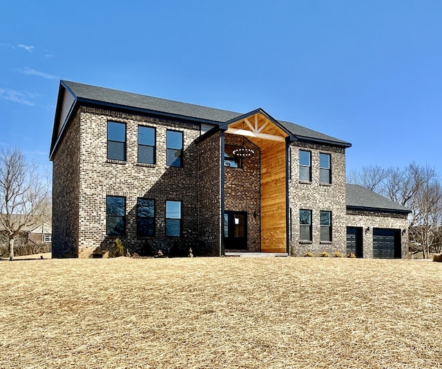 view of front of property with a garage and brick siding