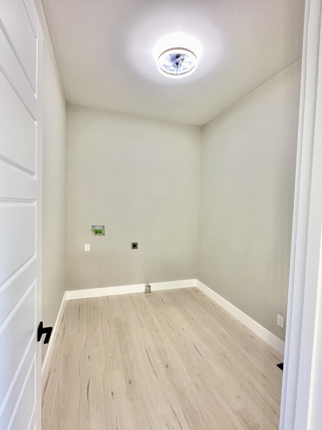 clothes washing area with light wood-type flooring, baseboards, hookup for a washing machine, and laundry area