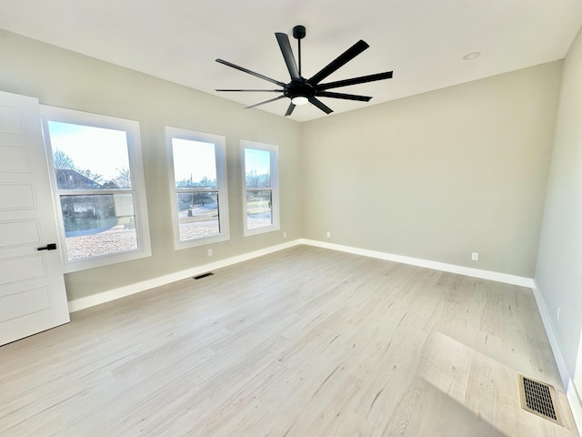 unfurnished room featuring light wood-style floors, a healthy amount of sunlight, and visible vents