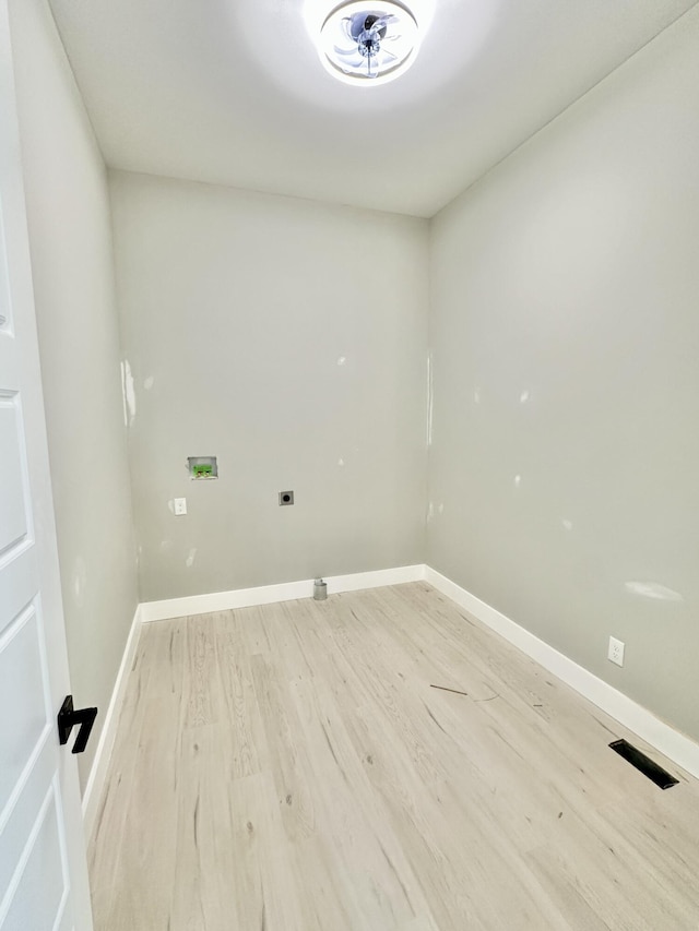 clothes washing area featuring visible vents, baseboards, hookup for a washing machine, and light wood finished floors