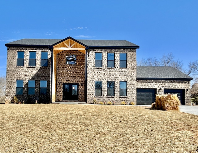 view of front of property with a garage, brick siding, concrete driveway, and a front lawn