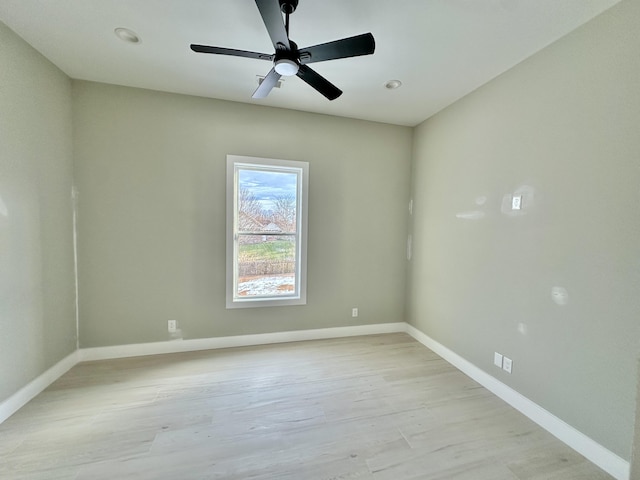 empty room featuring baseboards, light wood-style floors, and a ceiling fan