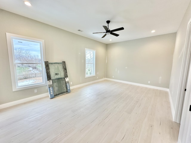 unfurnished living room with light wood finished floors, baseboards, and a wealth of natural light