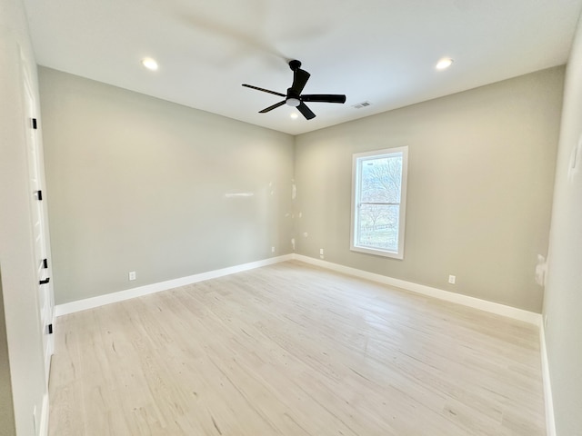 spare room with visible vents, ceiling fan, baseboards, and light wood-style floors