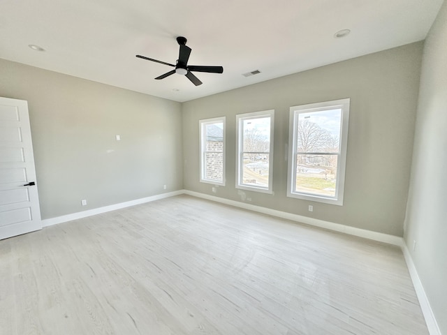 empty room with light wood-type flooring, visible vents, baseboards, and ceiling fan