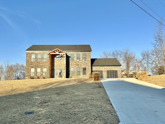 view of front of house with brick siding, driveway, and a garage