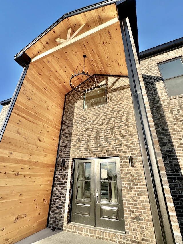 view of exterior entry with french doors and brick siding