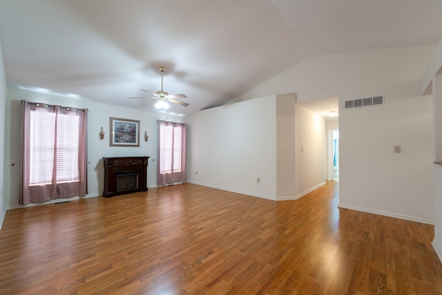 unfurnished living room with dark hardwood / wood-style floors, ceiling fan, and vaulted ceiling