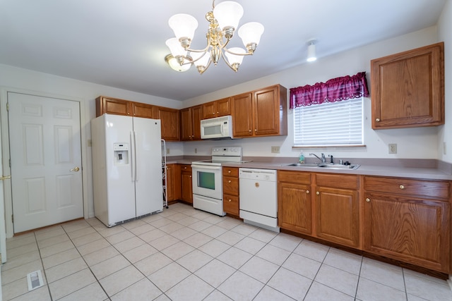 kitchen with pendant lighting, white appliances, an inviting chandelier, sink, and light tile patterned flooring