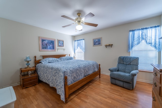 bedroom with light wood-type flooring, multiple windows, and ceiling fan