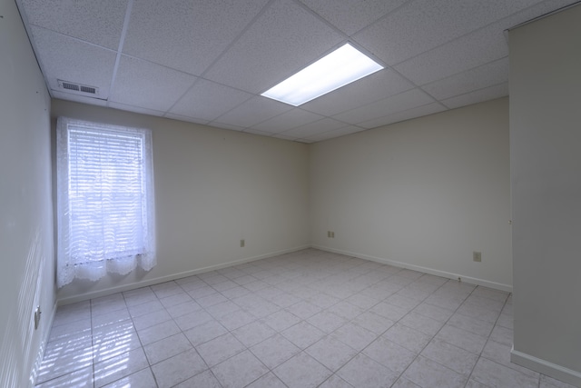 tiled empty room with a drop ceiling