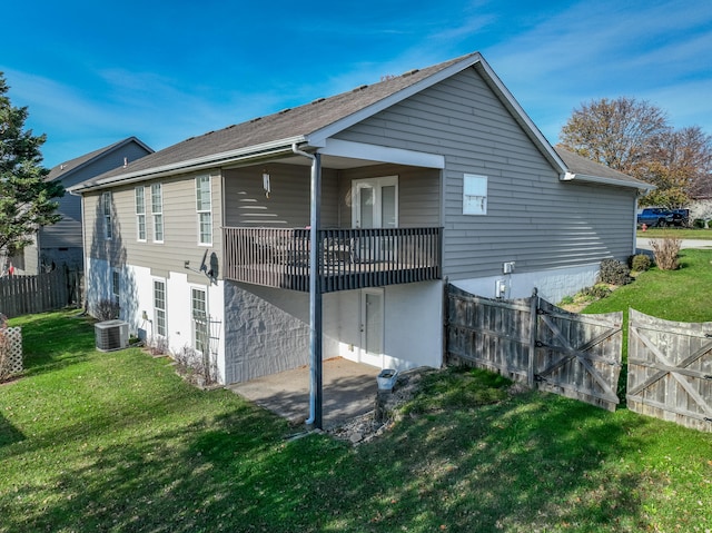 rear view of house with a patio, a deck, cooling unit, and a lawn