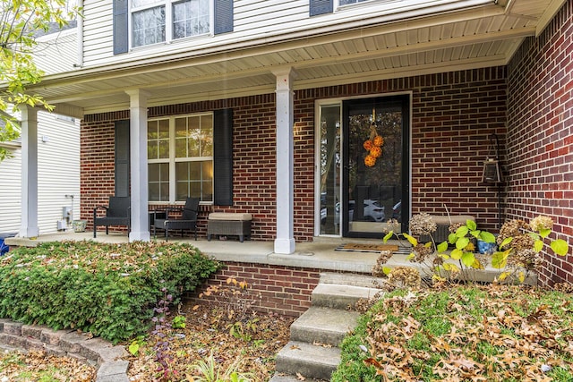 view of exterior entry featuring covered porch