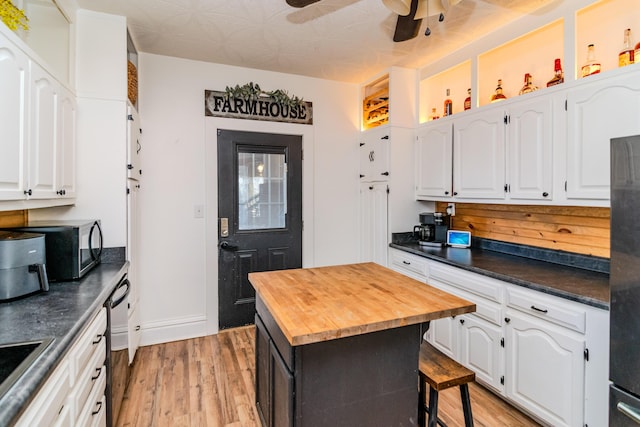 kitchen with white cabinets, light wood-type flooring, stainless steel appliances, and a kitchen island