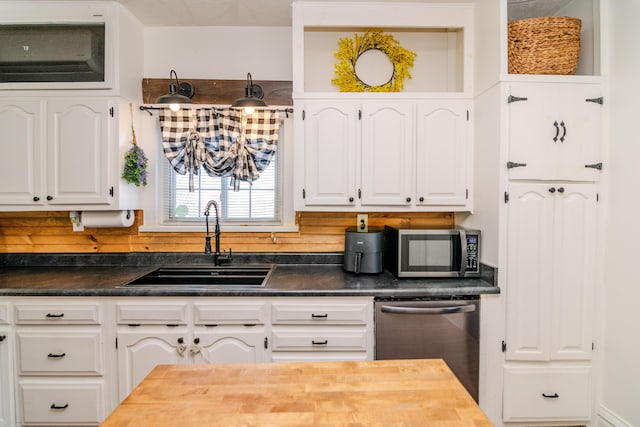 kitchen with white cabinets, stainless steel appliances, tasteful backsplash, and sink