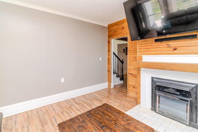 unfurnished living room with wooden walls and light wood-type flooring