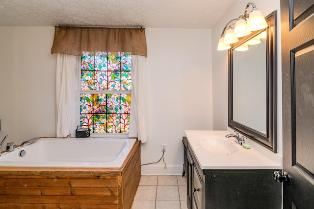 bathroom with tile patterned floors, a tub, vanity, and a textured ceiling