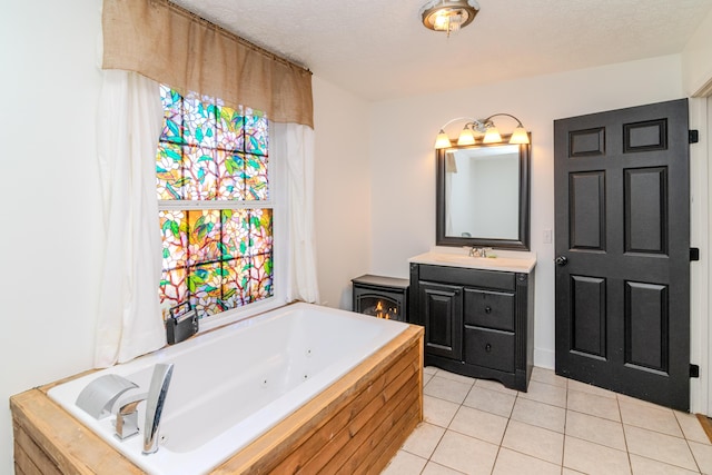 bathroom featuring tile patterned flooring, vanity, a textured ceiling, and a washtub