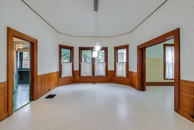 unfurnished room featuring light hardwood / wood-style floors and wooden walls