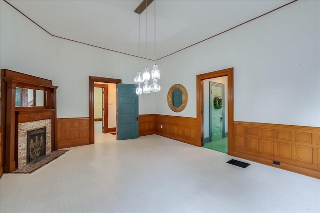 interior space with a fireplace, a notable chandelier, and wood walls