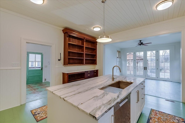 kitchen featuring pendant lighting, a center island with sink, white cabinetry, and sink