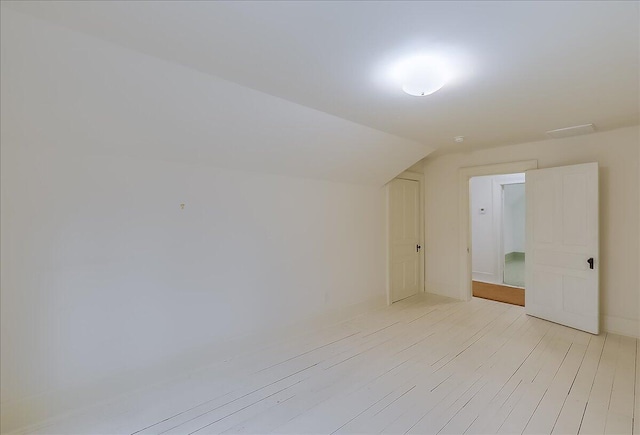 additional living space featuring light hardwood / wood-style flooring and lofted ceiling