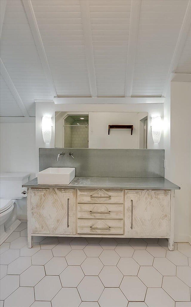 bathroom with lofted ceiling with beams, toilet, and vanity