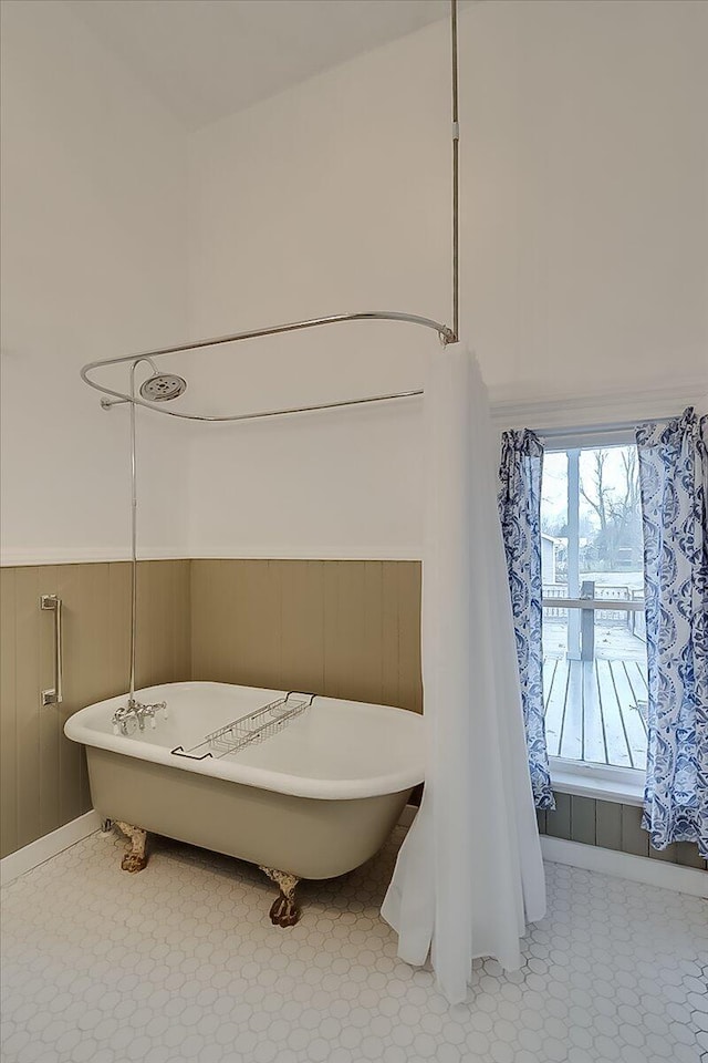 bathroom featuring a bathing tub and wood walls