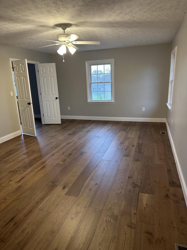 unfurnished room with ceiling fan, baseboards, and dark wood-style flooring