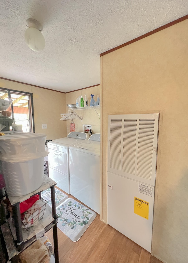 laundry area featuring wood-type flooring, a textured ceiling, and independent washer and dryer