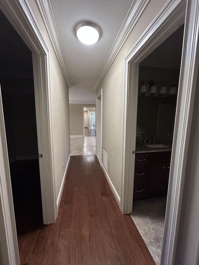 hall featuring ornamental molding, dark hardwood / wood-style flooring, and sink