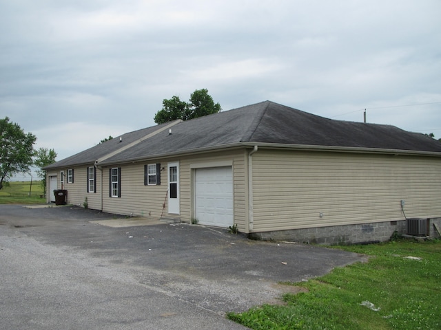 view of property exterior featuring a garage and central AC