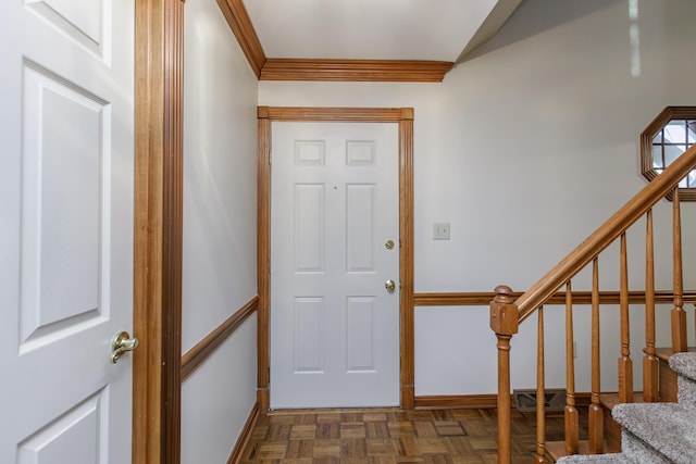 entrance foyer featuring crown molding and dark parquet floors