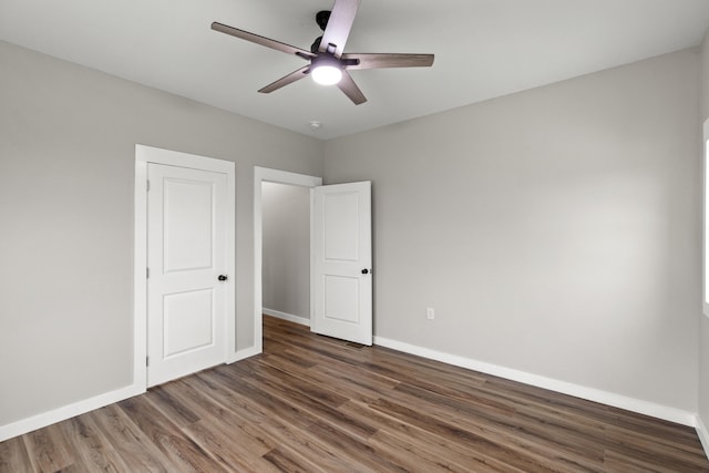 unfurnished bedroom featuring ceiling fan and dark hardwood / wood-style floors