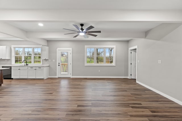 unfurnished living room featuring ceiling fan, plenty of natural light, and hardwood / wood-style flooring