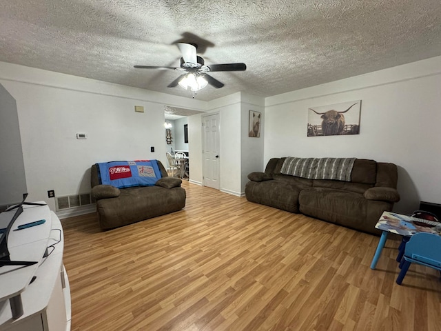 living room with light hardwood / wood-style floors and a textured ceiling