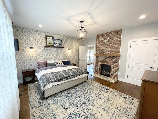 bedroom featuring a fireplace and dark hardwood / wood-style flooring