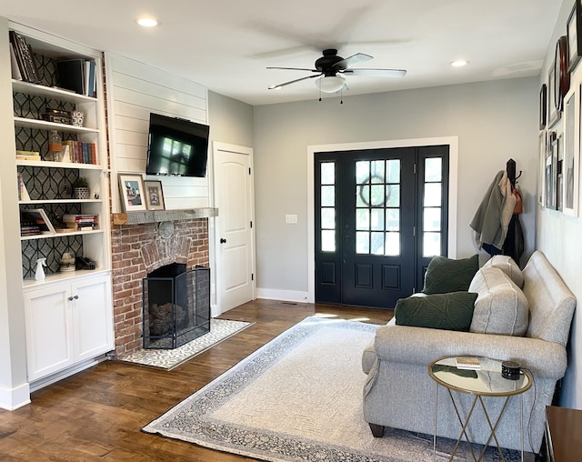 living room with ceiling fan, dark wood-type flooring, and a brick fireplace