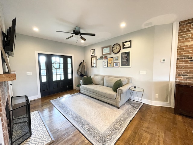 living room with dark hardwood / wood-style floors, ceiling fan, and a fireplace