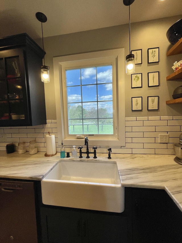 kitchen featuring dishwashing machine, hanging light fixtures, and sink