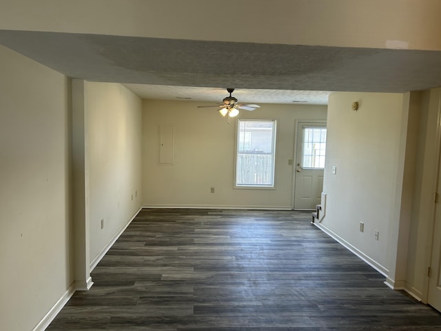 spare room featuring dark wood-type flooring, ceiling fan, and a textured ceiling