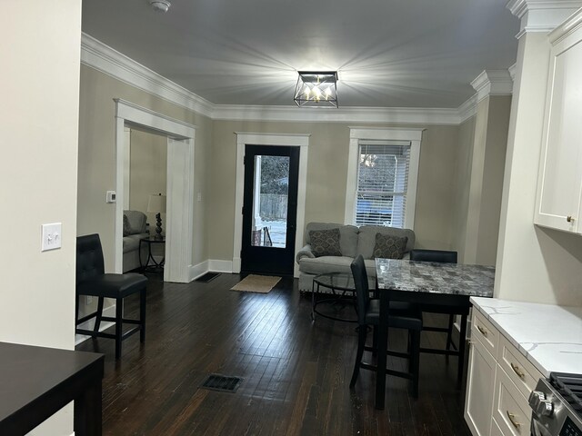 kitchen featuring white cabinets, crown molding, dark wood-type flooring, and appliances with stainless steel finishes