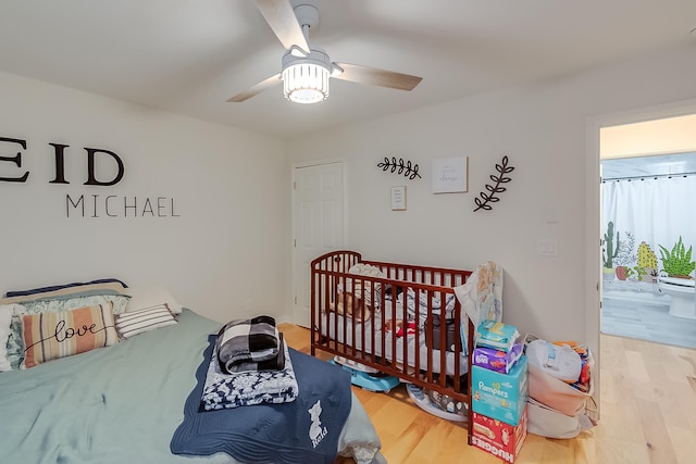 bedroom with ensuite bath, ceiling fan, light hardwood / wood-style flooring, and a nursery area