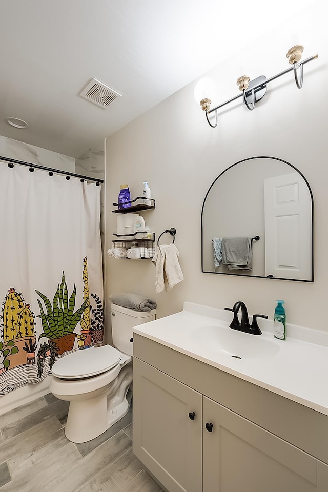 bathroom featuring vanity, wood-type flooring, and toilet