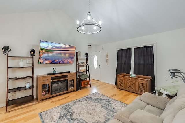 living room featuring a chandelier, wood-type flooring, and lofted ceiling